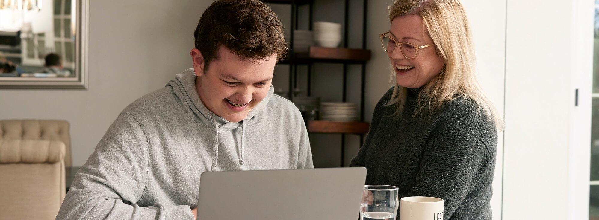 LGS patient, Cameron (18), using his laptop while his mother watches over.