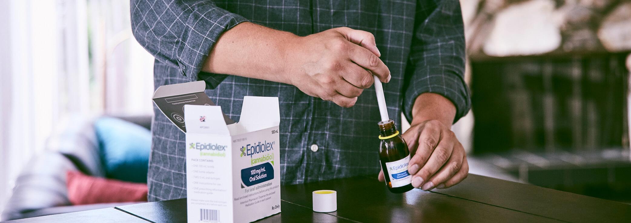 Man about to administer EPIDIOLEX® (cannabidiol) FDA approved prescription CBD medicine.